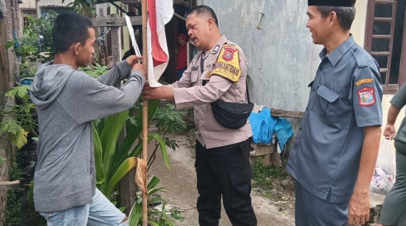 Sambut HUT RI, Bhabinkamtibmas Polsek Tanjung Balai Utara Ajak Warga Pasang Bendera Merah Putih